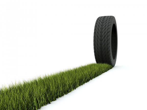 Tire with track from grass isolated on white