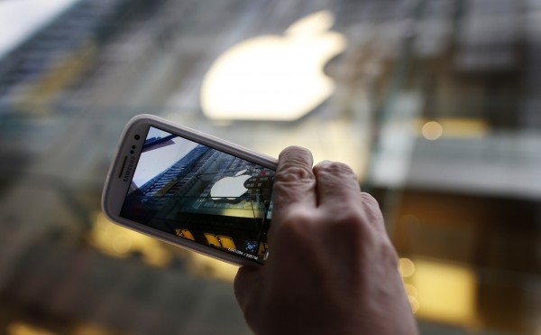 A passerby photographs an Apple store logo with his Samsung Galaxy phone on the morning iPhone 5 goes on sale to the public in central Sydney September 21, 2012. Apple Inc's iPhone 5 hit stores around the globe on Friday, with fans snapping up the device that is expected to fuel a huge holiday quarter for the consumer giant. REUTERS/Tim Wimborne (AUSTRALIA - Tags: BUSINESS TELECOMS SCIENCE TECHNOLOGY)